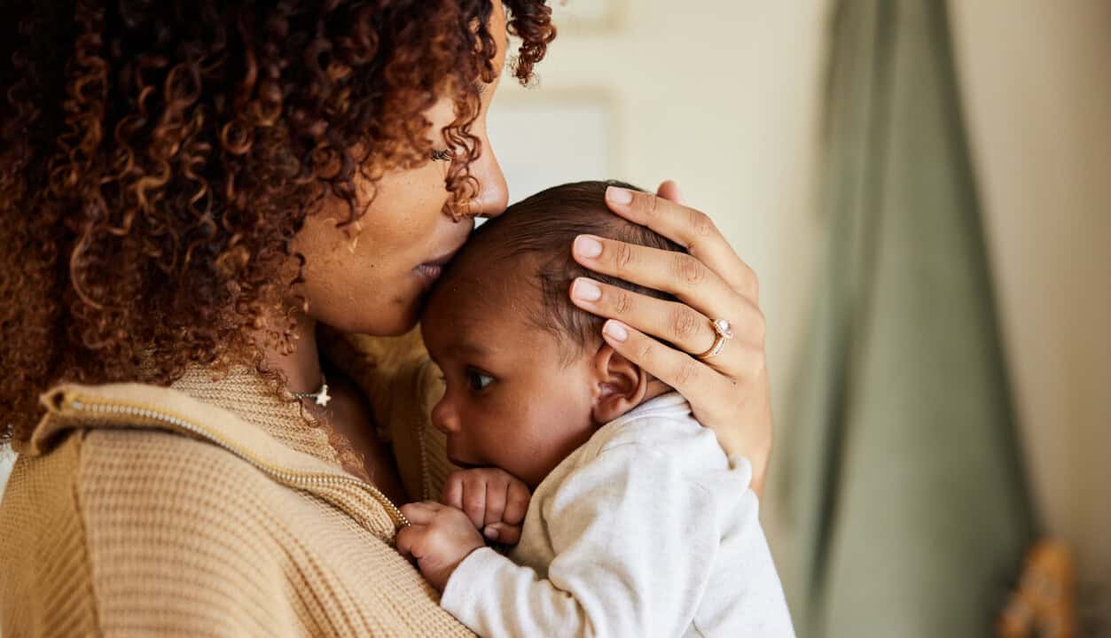 A woman is holding her baby in her arms.